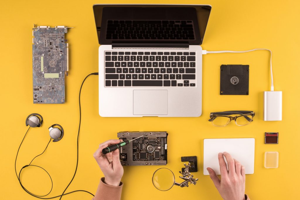 cropped shot of person fixing laptop on yellow
